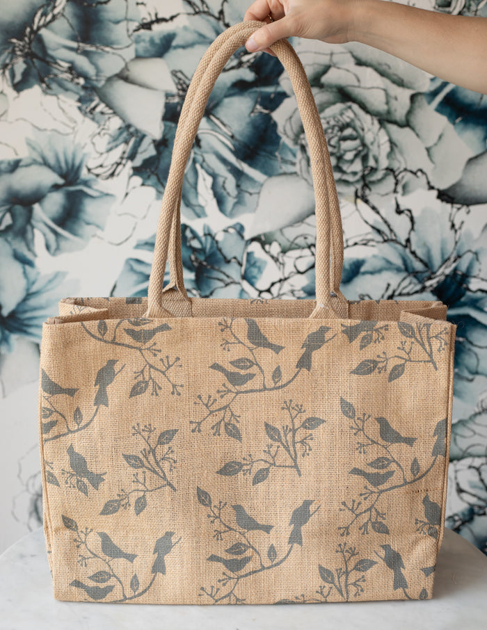 Beige jute tote bag with a bird print.