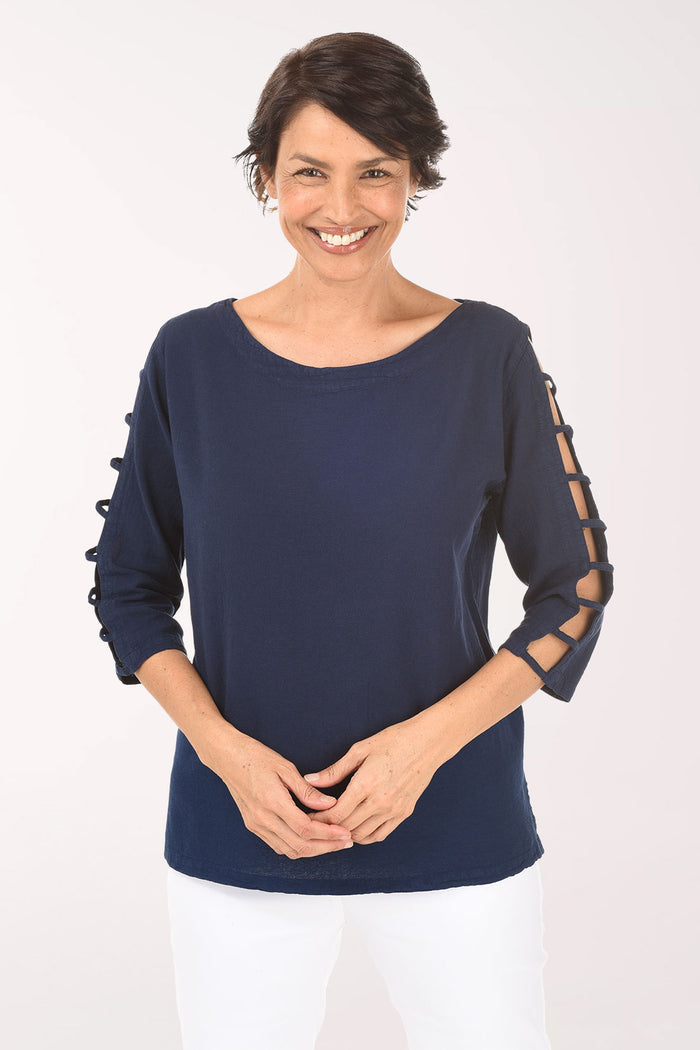 Woman wearing a navy blue top with cut-out sleeves on a white background