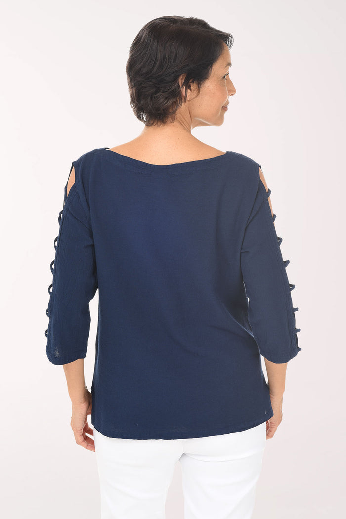 Woman wearing a navy blue top with cut-out sleeves on a white background