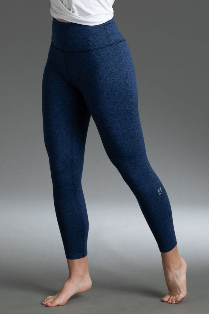 Navy blue leggings worn by a person on a gray background || Navy