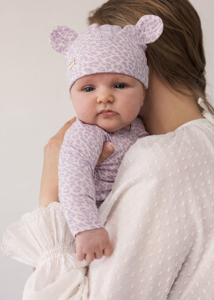 Baby wearing a knitted hat with ears and matching outfit.