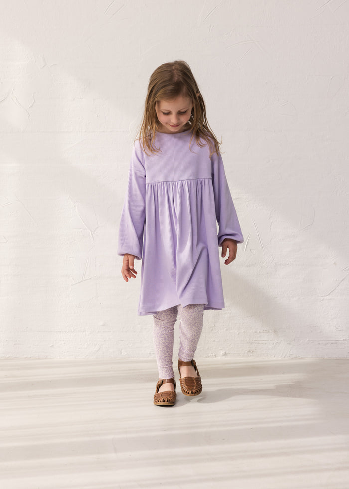 Wearing a purple dress and leopard leggings.
