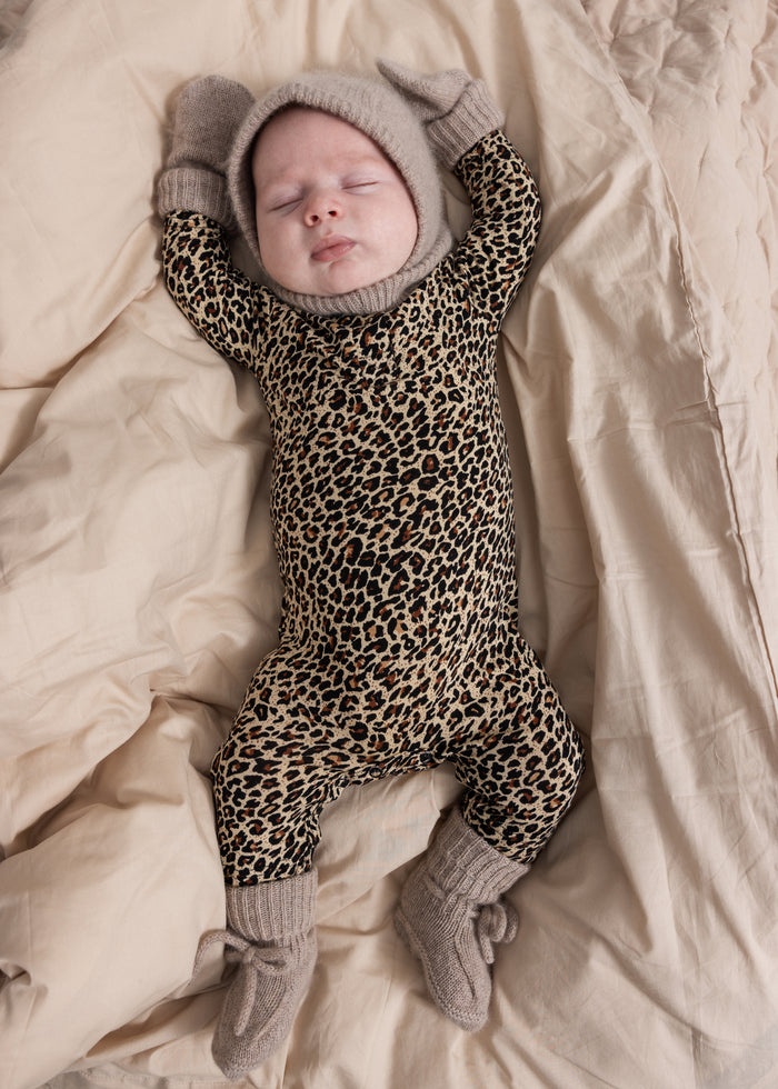 Leopard print jumpsuit with hood and gray ribbed edges, full-length legs and feet.