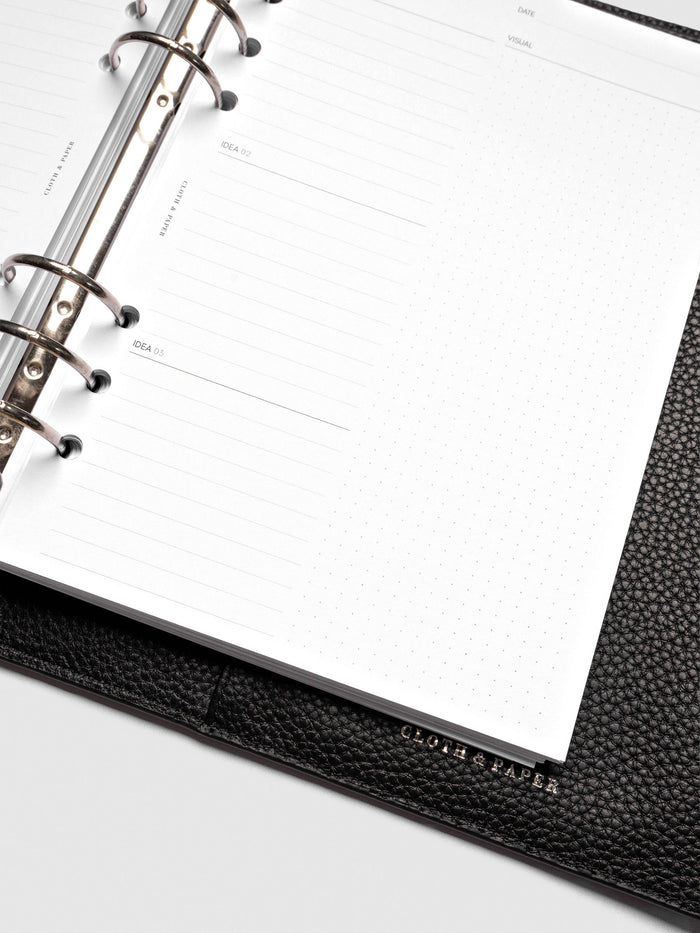 Close up of Mental Download inserts inside discbound planner and leather cover.