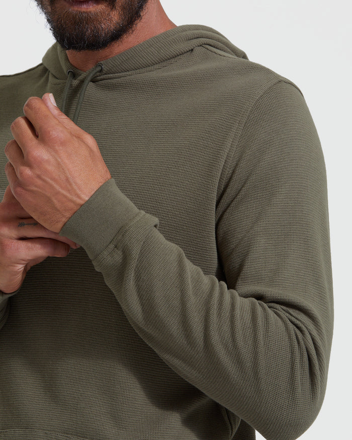 Man wearing Military Green Waffle Hoodie adjusting drawstring.