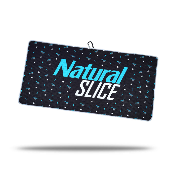 The Natural Slice - Towel is a rectangular black microfiber towel featuring small blue and white geometric patterns, "Natural SLICE" in bold blue and white text, a black hanging loop with clip and eyelet, plus two-sided print.