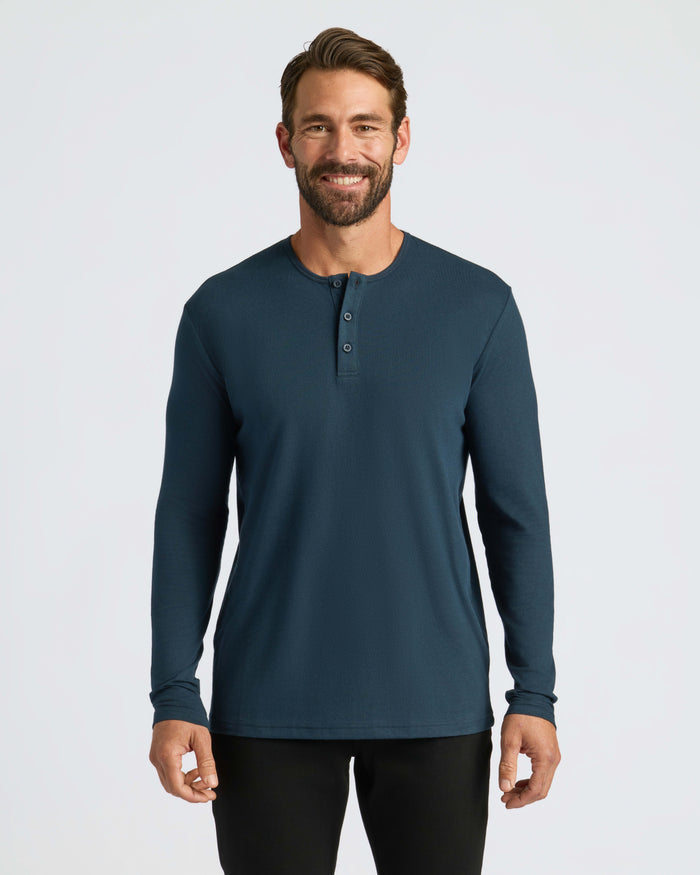 Man wearing Navy Classic Long Sleeve Henley and black pants, smiling.