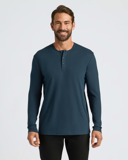 Man wearing Navy Classic Long Sleeve Henley and black pants, smiling.