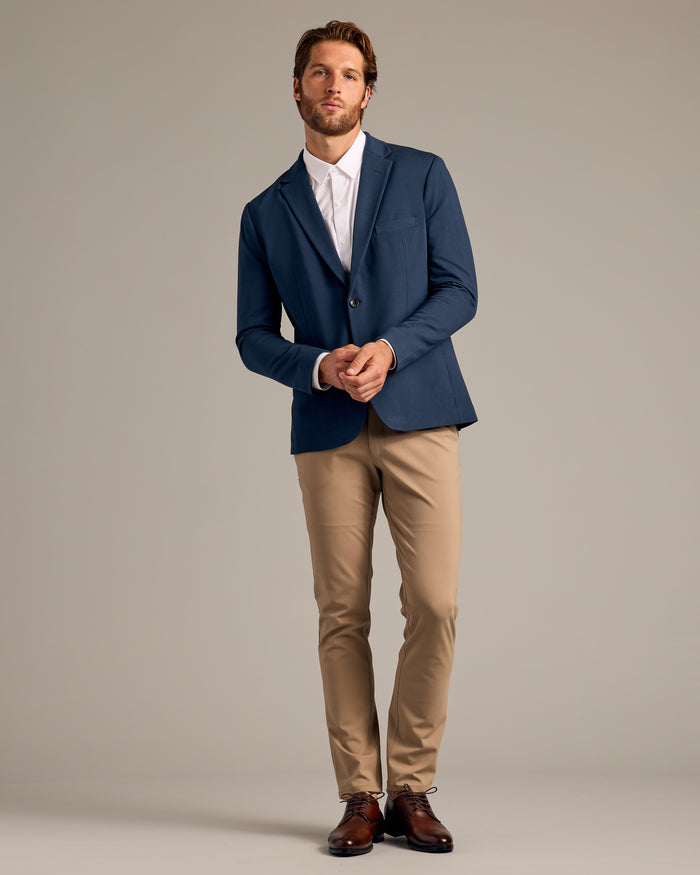 Man in Navy Comfort Knit Blazer, white shirt, khaki trousers.