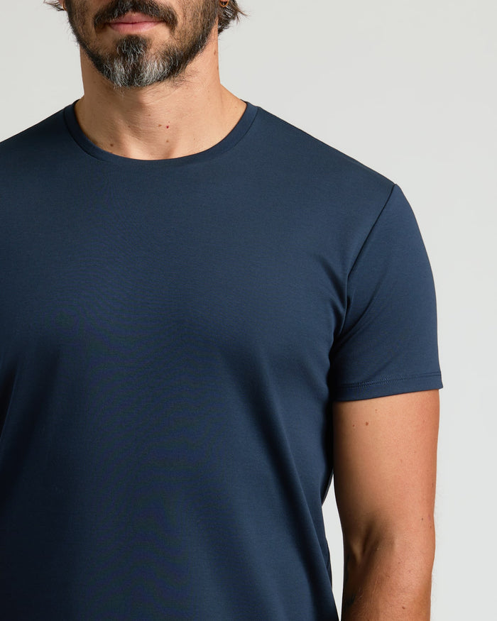 Close-up of a man wearing a Navy Pima Cotton Blend Curved Hem Crew, showcasing a smooth, fitted fabric and classic crew neckline in a men's basics style.