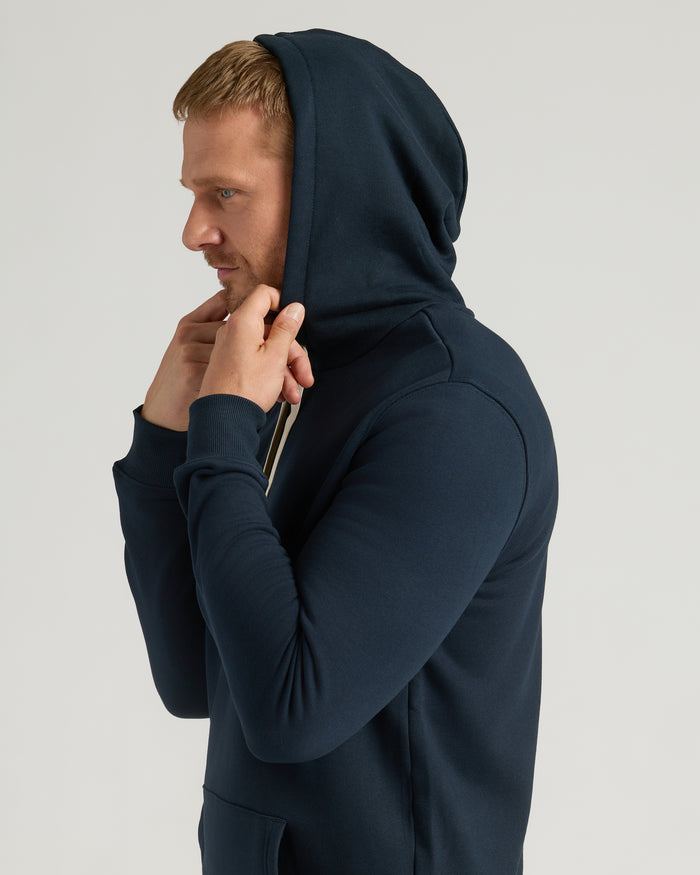 Man wearing Navy Tall Fleece French Terry Pullover Hoodie, adjusting hood.