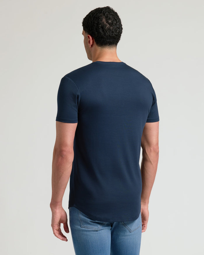 A man wearing a navy Tall Pima Cotton Blend Curved Hem Crew 4-Pack t-shirt, shown from the back, paired with light blue jeans against a plain background.