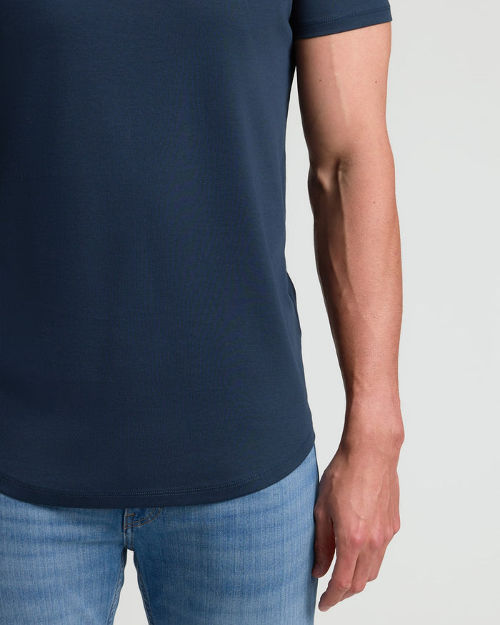Close-up of a man wearing a Navy Tall Pima Cotton Blend Curved Hem Crew shirt paired with light blue jeans, highlighting the curved hem and soft fabric texture.