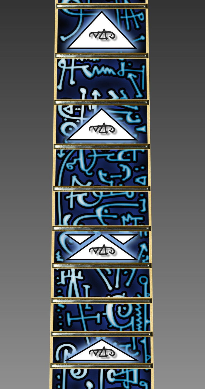 up close image of the fret protector. it has a lot of abstract shapes in black, white, and light blue. some of the spaces have white triangles with a black outline with the steve vai logo in the center. The steve vai logo makes the word "vai" with an upside down triangle, a right side up one, and a line going across the triangles with a curl at the end next to the triangle that is upright.