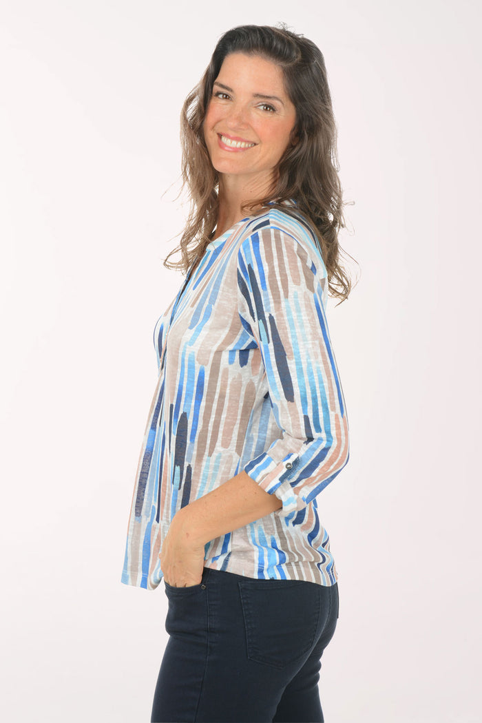 A woman wearing a multicolored 3/4 sleeve top.