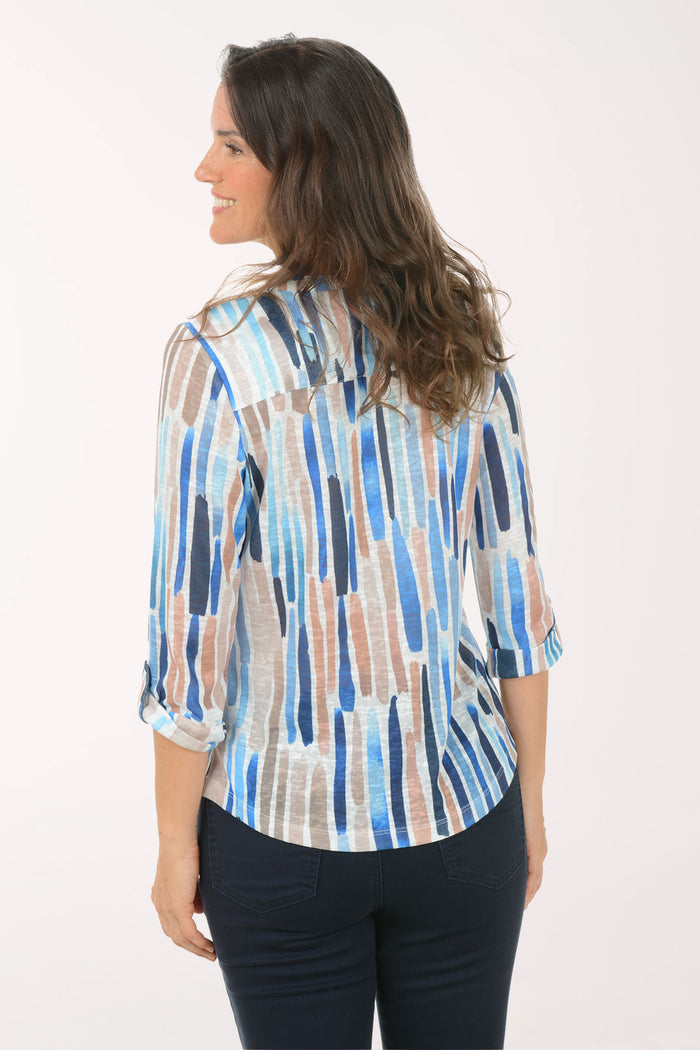 A woman wearing a multicolored 3/4 sleeve top.