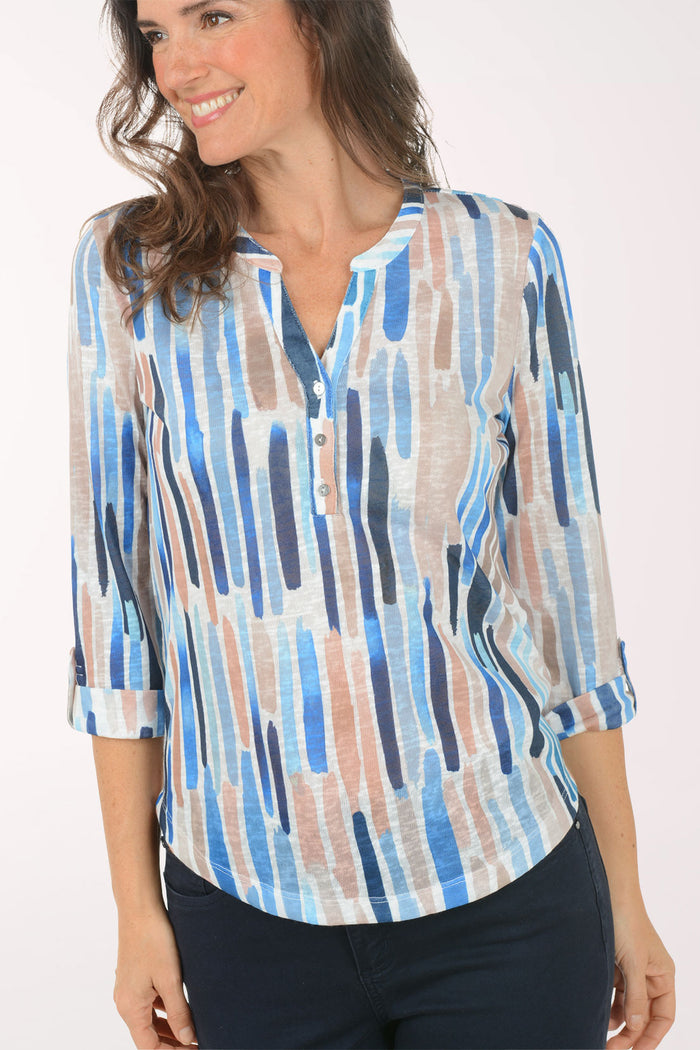 A woman wearing a multicolored 3/4 sleeve top.