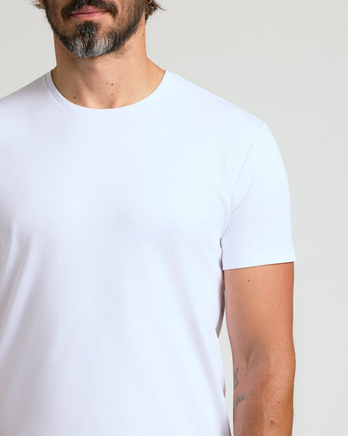 Close-up of a man wearing a white Pima Cotton Blend Curved Hem Crew 7-Pack t-shirt, showcasing the soft fabric and classic crew neck fit, a men's basics essential.