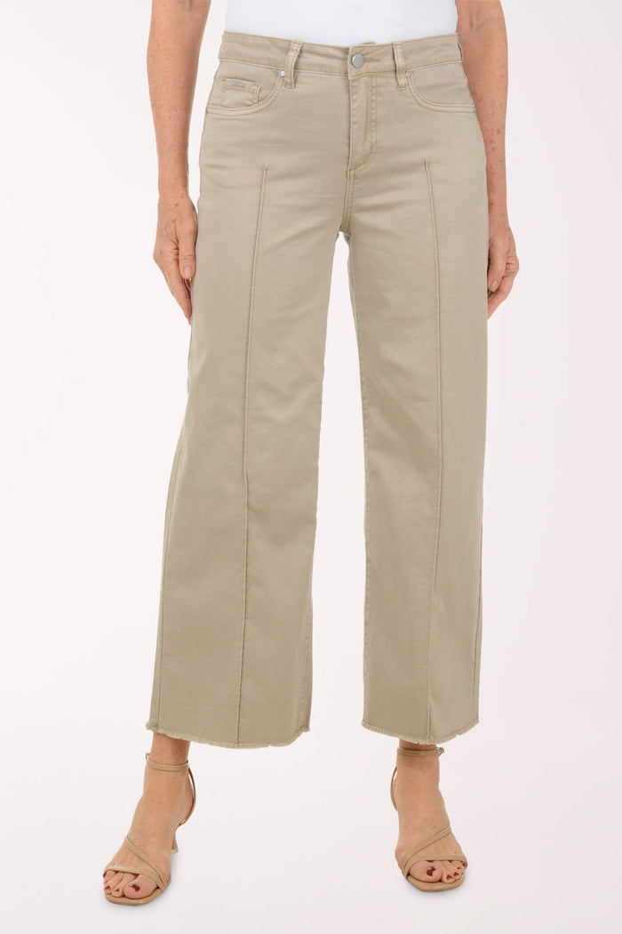 A woman wearing a flared brown crop pant.