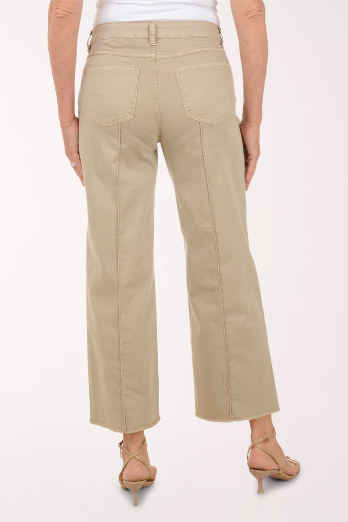 A woman wearing a flared brown crop pant.