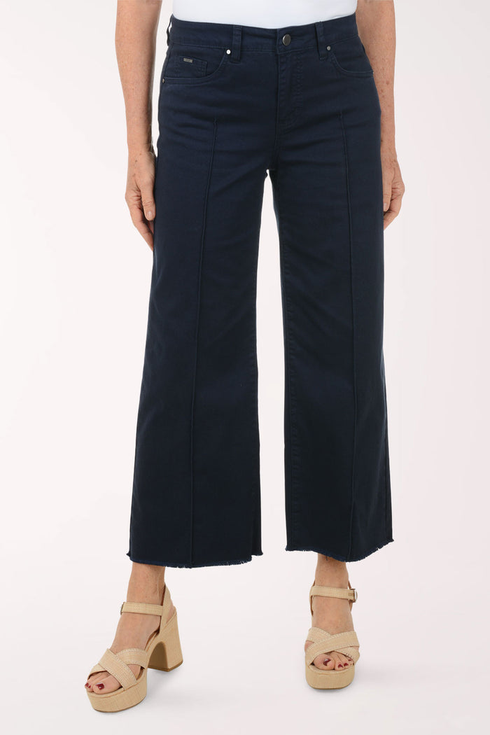 A woman wearing a flared navy crop pant.