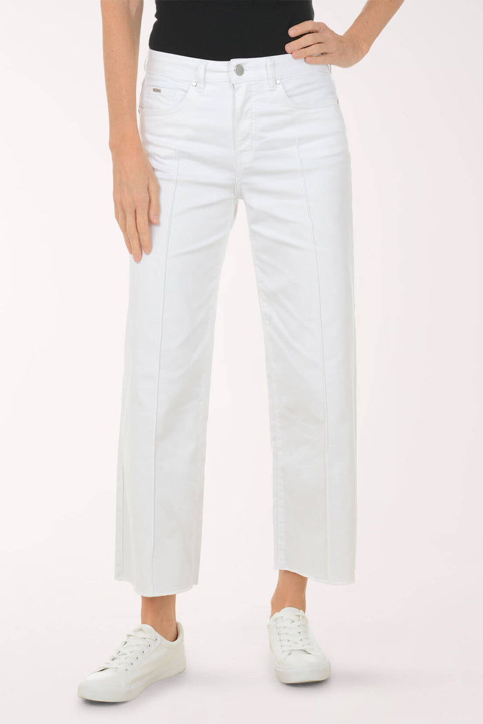 Person wearing white jeans on a plain background