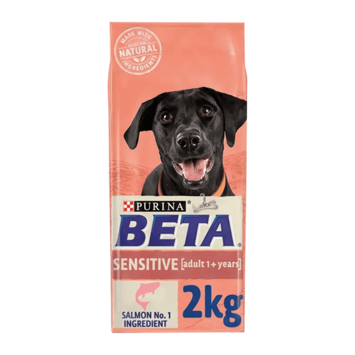 White background with a pink bag of Purina Beta Sensitive Adult Dog Food. Pictured on the bag is a black Labrador dog, text on the bag reads 'Purina Beta, Sensitive, Adult (1+ years) Salmon No.1 Ingredient.'