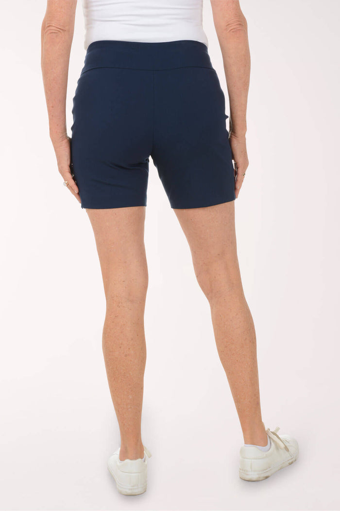 Person wearing navy blue shorts on a white background. Back shot