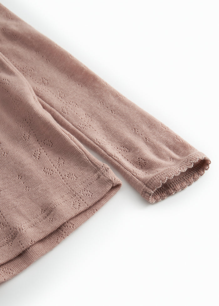 Detalje af rosa uld T-shirt: lange ærmer med ribkant og pointelle-mønster.