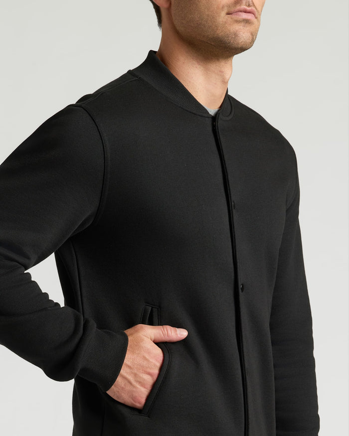 Black Fleece Bomber Jacket on model, showcasing ribbed collar and cuffs.