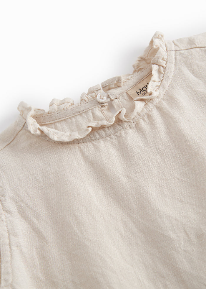 Sleeveless beige top for children with pleats.