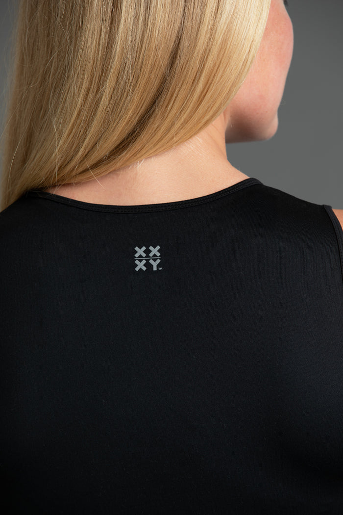 Black sleeveless top with a logo on the back, worn by a person. || Black