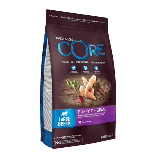 White background with a picture of a bag of Wellness CORE Original Puppy Food. On the bag is pictures of chicken fillets, peas, cranberries and a beet. The text on the bag 'Wellness CORE, Natural, Grain Free, Protein-Rich' and 'Large breed, Puppy Original, Chicken Recipe'.