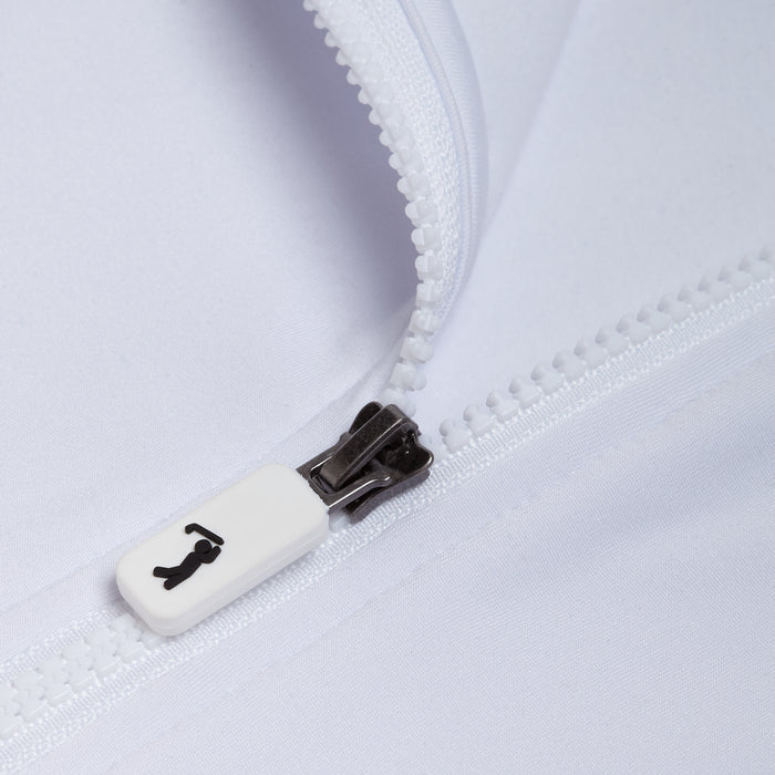 Close-up of the White - Q-Zip’s white zipper against a white fabric. The pull shows a small black icon. The fabric provides UPF 50 sun protection and moisture wicking, while the partially open zipper reveals its textured teeth.