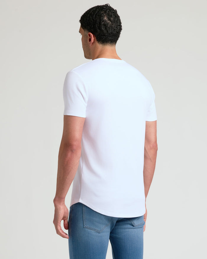 Man wearing a white Tall Pima Cotton Blend Curved Hem Crew 7-Pack t-shirt, showcasing the curved hem and comfortable fit, paired with blue jeans.